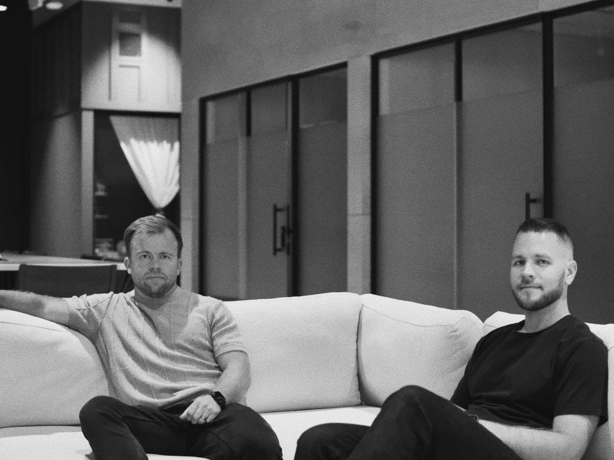 AMP IT founders Nik Kotov and Mikhail Koval seated in a Charlotte office.